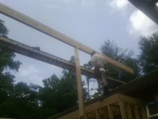 Carpenter setting a ridge beam over a new addition frame — Ice Dam Removal by Roofing Brothers in Copeland