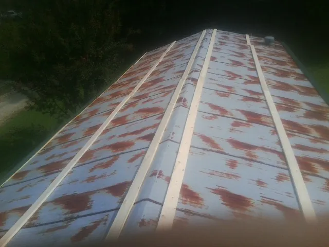 Rusted metal roof panels with new wood purlins before replacement — Storm Damage Roof Repair in Copeland by Roofing Brothers