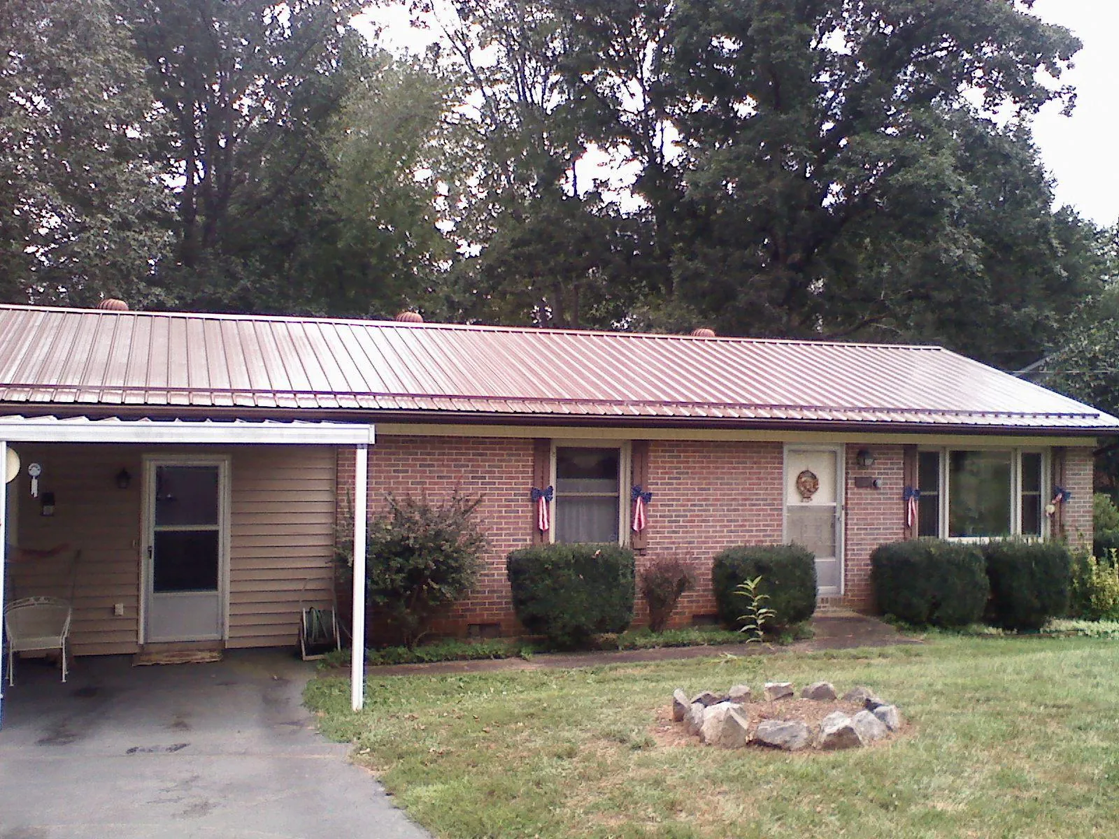 Bronze metal roof and carport on a brick ranch home — Roof Repair work by our crew in Copeland