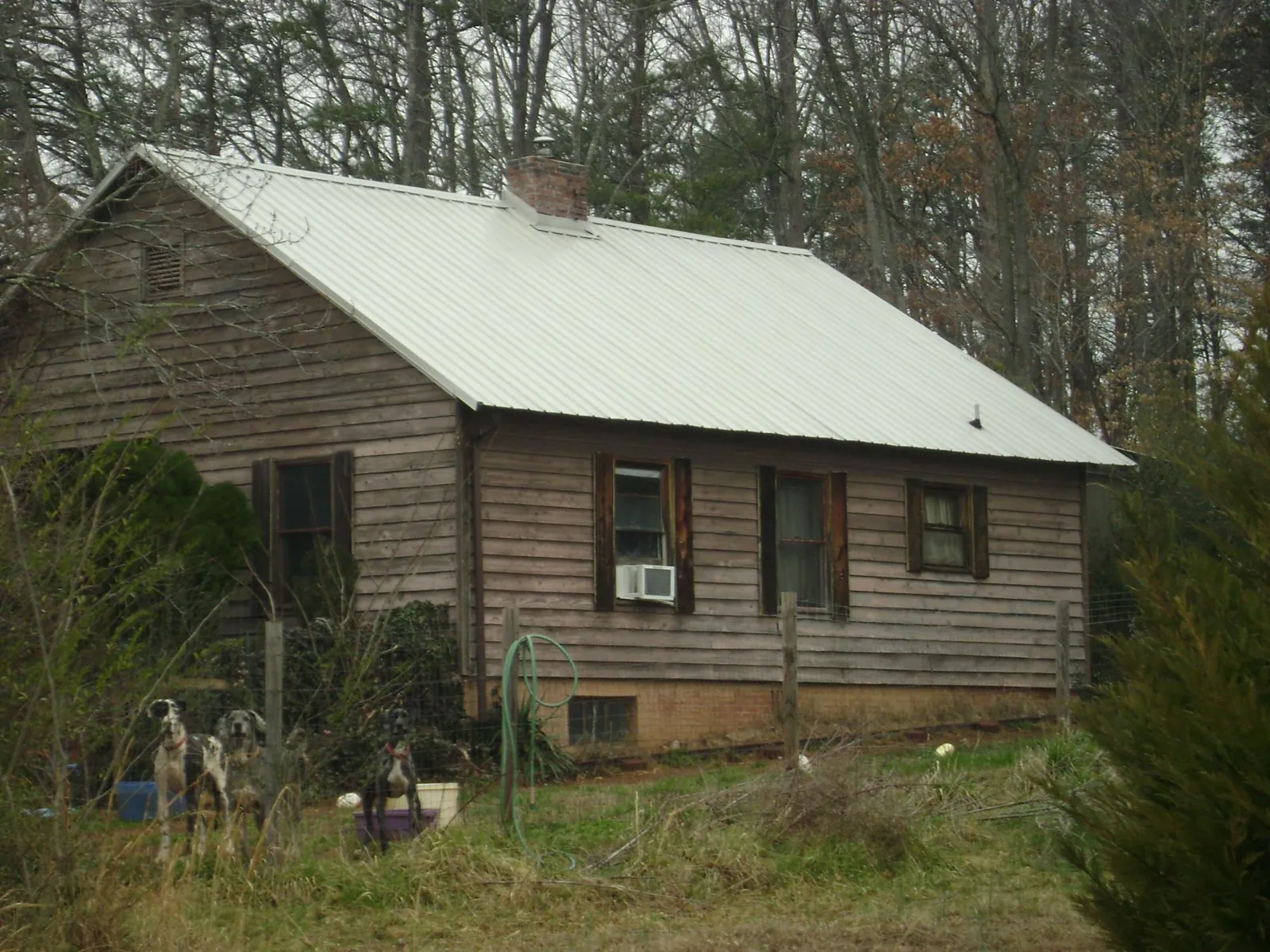 White metal roof on an old wood sided farmhouse, from a Metal Roof Installation job in Copeland